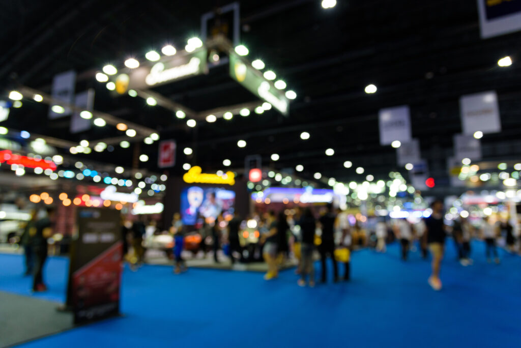 Ambiente de feira de negócios com público e estandes no setor de logística e transporte.
